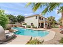 Backyard oasis features a pool, lush landscaping, a covered patio with an outdoor kitchen at 1515 E Saratoga Ct, Gilbert, AZ 85296