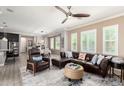 Bright living room featuring a leather sofa, ceiling fan, and an open floor plan to the dining area at 1930 W Yellowstone Way, Chandler, AZ 85248