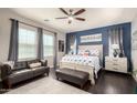 Main bedroom featuring a blue accent wall, a king-size bed, and a comfortable seating area at 1930 W Yellowstone Way, Chandler, AZ 85248