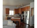 Open concept kitchen features stainless appliances, wood cabinets and breakfast bar seating at 2401 E Rio Salado Pkwy # 1225, Tempe, AZ 85288