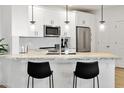 Well-lit kitchen offers stainless steel appliances, white cabinetry, and a sleek breakfast bar with black stools at 2511 W Queen Creek Rd # 165, Chandler, AZ 85248