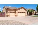 Charming single-story home featuring a three car garage and desert landscaping at 2528 N Ashbrook Cir, Mesa, AZ 85213