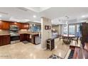 Open kitchen with stainless appliances, wood cabinets and wine storage; ample natural light and connecting dining area at 33 W Missouri Ave # 17, Phoenix, AZ 85013