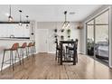Open dining area featuring modern pendant lighting, slider doors and stylish bar stools at 3841 E Jasper Dr, Gilbert, AZ 85296