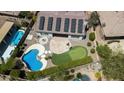 Aerial view of a private backyard with a pool, putting green, patio, and solar panels at 41817 N Bridlewood Way, Phoenix, AZ 85086