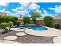 Backyard pool area showcasing decorative stone accents and mature landscaping at 41817 N Bridlewood Way, Phoenix, AZ 85086