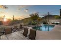 Resort-style backyard features a pool with rock waterfall, desert views and dining area at 4632 S Alamos Way, Gold Canyon, AZ 85118