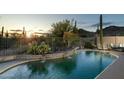 Inviting pool area showcases desert landscaping, rock waterfall and mountain views at 4632 S Alamos Way, Gold Canyon, AZ 85118