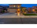 Beautiful two-story home with a welcoming entryway and lush landscaping at night at 4894 E Palm Beach Dr, Chandler, AZ 85249
