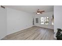 Bright living room with wood-look flooring, a ceiling fan, and windows with white shutters at 5350 E Deer Valley Dr # 2435, Phoenix, AZ 85054