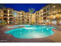 Resort style pool and spa illuminated at night with lounge chairs and umbrellas at 5350 E Deer Valley Dr # 2435, Phoenix, AZ 85054