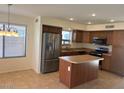 A modern kitchen featuring stainless steel appliances, wood cabinets and a center island at 56 W Holstein Trl, San Tan Valley, AZ 85143