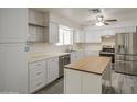 A well-lit kitchen with stainless steel appliances, white cabinets, and tile backsplash awaits a home chef at 7135 E Baywood Ave, Mesa, AZ 85208