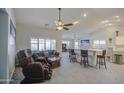 Inviting living room with a ceiling fan, comfortable leather seating, and tiled floors throughout at 737 W Desert Valley Dr, San Tan Valley, AZ 85143