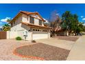 Charming two-story home featuring a tile roof, two-car garage, and desert landscaping at 7402 W Kerry Way, Glendale, AZ 85308