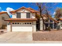 Charming two-story home featuring a tile roof, two-car garage, and desert landscaping at 7402 W Kerry Way, Glendale, AZ 85308