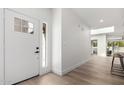 Bright and modern foyer with clean lines, wood floors, and a stylish front door with sidelight at 7467 E Pleasant Run, Scottsdale, AZ 85258