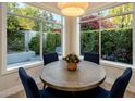 Cozy dining area featuring a round table and large windows offering views of the lush outdoor landscaping at 7979 E Princess Dr # 26, Scottsdale, AZ 85255