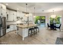 Spacious kitchen with white cabinetry, central island with seating, and stainless steel appliances at 7979 E Princess Dr # 26, Scottsdale, AZ 85255