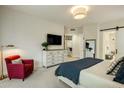 Bright main bedroom featuring a dresser, red chair, and neutral decor at 7979 E Princess Dr # 26, Scottsdale, AZ 85255