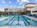 Large community swimming pool with lap lanes and a modern recreation center building at 8577 W Trenton Ct, Florence, AZ 85132