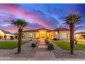 Stunning single-story home with lush landscaping, stone pathway, and palm trees at 16465 W Mohave St, Goodyear, AZ 85338