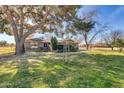 Expansive front yard showcasing mature trees, lawn, and a charming home facade with stone accents at 2017 E Willis Rd, Gilbert, AZ 85297