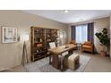 This office features a decorative bookshelf, office desk, and two chairs for a relaxing space at 2408 W Crimson Ter, Phoenix, AZ 85085