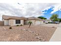 Single-story home featuring a three-car garage, xeriscaping, and a mature palm tree at 10513 W Wilshire Dr, Avondale, AZ 85392