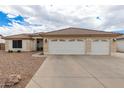 Charming single-story home showcasing a three-car garage and a meticulously maintained desert landscape at 10513 W Wilshire Dr, Avondale, AZ 85392