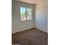 Bedroom with carpet flooring and a window view showcasing a bright space awaiting personalization and renovation at 11918 W Aster Dr, El Mirage, AZ 85335