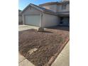 A stucco house with a two car garage and a desert style front yard with a boulder at 11918 W Aster Dr, El Mirage, AZ 85335