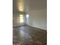 A bright living room with tiled floors, white walls, and large windows with natural light at 11918 W Aster Dr, El Mirage, AZ 85335