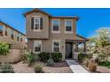 Two-story townhome showcasing neutral stucco, dark shutters, and desert landscaping at 2640 N Heritage St, Buckeye, AZ 85396