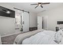 Bright main bedroom boasts a ceiling fan, TV, and access to the ensuite bathroom with a barn door at 4060 E French Trotter St, San Tan Valley, AZ 85140
