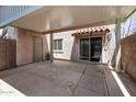Private covered patio area showcasing a concrete floor, access door, and sliding glass door at 600 S Dobson Rd # 67, Mesa, AZ 85202