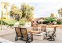 Beautiful backyard patio featuring a modern fire pit, seating, and manicured greenery at 10266 E Caron St, Scottsdale, AZ 85258
