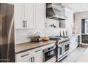 Modern kitchen with professional grade stainless steel appliances, white cabinets, and gray countertops at 10266 E Caron St, Scottsdale, AZ 85258