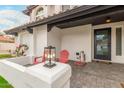 Inviting front porch with stylish seating, a decorative lantern, and a welcoming front door at 10775 N 101St St, Scottsdale, AZ 85260