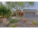Charming desert landscaping with river rock features a stone pathway to the front door at 32868 N 69Th St, Scottsdale, AZ 85266