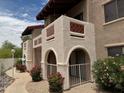 A charming condo with desert landscaping, arches, and private balcony entrances on each level at 5757 W Eugie Ave # 1038, Glendale, AZ 85304