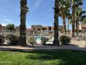 Lovely community pool area with palm trees, pristine water, and manicured landscaping at 5757 W Eugie Ave # 1038, Glendale, AZ 85304