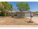 Charming single-story home featuring a two-car garage and mature shade trees in the front yard at 8129 N 17Th Dr, Phoenix, AZ 85021