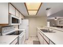 Functional kitchen with white appliances, ample counter space, and view into the living area at 1021 S Greenfield Rd # 1194, Mesa, AZ 85206