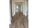 Inviting hallway featuring elegant wood-look tile flooring leading to sunlit rooms at 14742 W Lariat Trl, Surprise, AZ 85387
