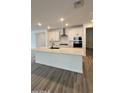 Bright kitchen boasts large island, modern appliances, white cabinets, and sleek design at 14742 W Lariat Trl, Surprise, AZ 85387