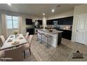 Modern kitchen boasts granite countertops, stainless steel appliances, and an island with bar seating at 3021 N 306Th Ln, Buckeye, AZ 85396
