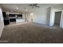 Spacious living room area featuring neutral carpet and an open floor plan leading into the kitchen at 3021 N 306Th Ln, Buckeye, AZ 85396