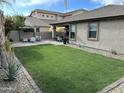 A backyard featuring a lush lawn, desert landscaping, and a paved patio with a pergola at 3021 W Trapanotto Rd, Phoenix, AZ 85086