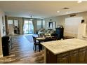 Open concept living area with wood-look flooring, dining area, and seamless connection to the outdoor patio at 3021 W Trapanotto Rd, Phoenix, AZ 85086